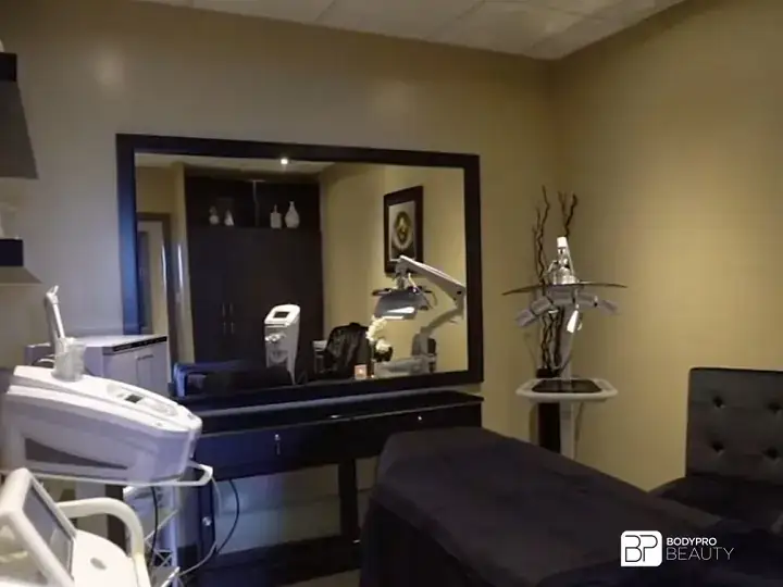 Practical learning area at Body Pro Beauty’s Brampton campus with treatment equipment and a service bed.
